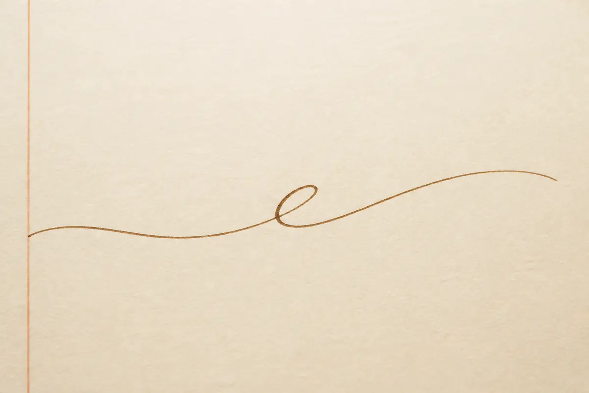 One cursive stroke on blank cream paper